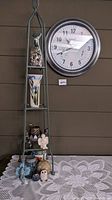 Full view of wrought iron shelf with multiple decorative items and SkyScan clock mounted on wall