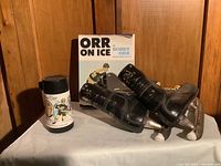 Group shot of skates, book and thermos on tabletop