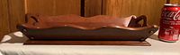 Wooden serving tray showing side profile with scalloped edges and built-in handles on each end.