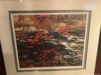 Full front view of framed print depicting red maple leaves and rocky river landscape.