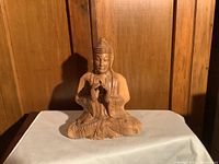 Front view of the wooden meditation Buddha statue showing hand carving details and seated posture.