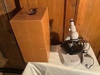 Carl Zeiss microscope with replacement tan carrying/storage case on table.