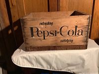 Front of wooden Pepsi-Cola crate showing 'refreshing satisfying Pepsi-Cola' text