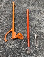 Full view of all three logging tools on asphalt: log splitting wedge, log splitter, and metal wedge.
