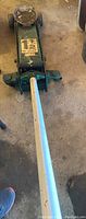 Full view of the automotive car jack showing the length of the handle and overall condition.