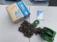 Jet chain hoist alongside original box and manual shown on table, highlighting condition and packaging.