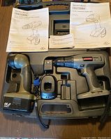 Pair of Craftsman cordless tools in carrying case with instruction manuals visible