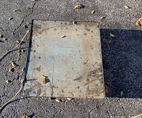 Top view of a vintage metal square flat dolly showing the metal surface, measuring approximately 25 1/4" by 28 1/4" with some dirt and rust spots.