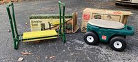 Photo of the kneeler seat with its box and the green multi-purpose seat bench with wheels and its box on an asphalt ground.