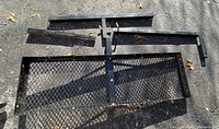 Full view of the Larin rear cargo carrier showing the heavy-duty steel mesh platform and hitch attachment.