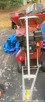 Front view of red Troy-Bilt chipper shredder showing hopper, brigs and stratton engine and tow bar attachment
