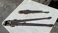 Photo of both vintage bolt cutters on table showing large and small sizes and embossed markings on handles.