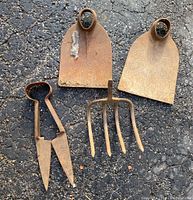 Image of two vintage metal garden shovel heads, one with visible rust and residue.
