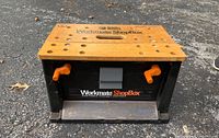 Front perspective view of the Black & Decker Workmate ShopBox showing the branded wooden top, side clamps, and storage compartment.