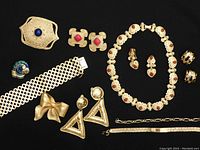 Overview of all jewelry pieces on black background showing variety and condition