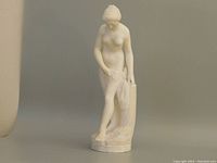Front view of the carved marble statue depicting a female figure standing and looking down.