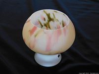 Photo of rounded frosted white art glass vase with pink and green swirls.