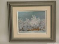 Framed oil painting with grey outer frame and off-white mat showing snow-covered trees in winter.