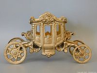 Side perspective of the antique cast iron royal coronation coach toy showing detailed bodywork and wheels.