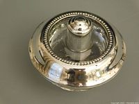 Photo of the sterling silver lighter showing the top with the beaded design and round shape.