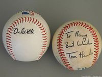 Photo showing two official MLB baseballs with signatures from Tom Henke and David Wells.