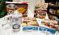 Photo showing Gotham Steel crisper tray box, Black & Decker citrus juicer, cake decorating pens, three fluted pastry cutters, and Taste of Home recipe books.