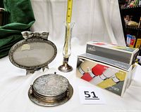 Wide shot showing the silver tone oval photo frame with bow, a floral etched coaster set with holder, the boxed napkin rings, and the 7-inch vase partially visible.