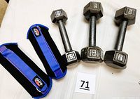Three hex cap dumbbells and two blue Pure Fitness ankle/wrist weights laid on a white surface.