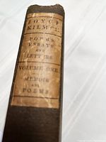 Photo of book spine showing paper label with title and volume information.