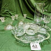 Full set showing swirled wavy glass Lazy Susan with four pieces, two double candle holders, pitcher, and glass.