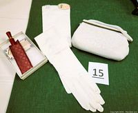Photo showing the full set including the white long gloves with tags, beaded white clutch purse, and vintage red perfume applicator in original box with instructions and cloth sheath.