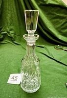 Front view of the full Wine Decanter with stopper in place on a green cloth background.