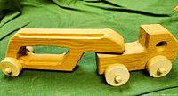Wooden carrier truck with trailer attached, showing natural wood finish and wheels.