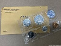 Seal containing five coins: Franklin half dollar, Washington quarter, Roosevelt dime, Jefferson nickel, Lincoln penny; with original envelope.