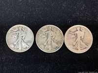 Obverse view of three Walking Liberty Half Dollar coins, showing 1943 dates on two coins, third coin date worn and indecipherable