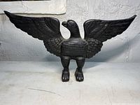 Front view of cast iron American eagle doorstop showing outstretched wings and detailed feathers