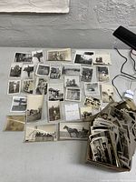 Overview of loose photographs laid flat and box of additional prints