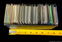 Side view of a box filled with closely packed Pokémon card stacks, showing thickness around 8 inches.