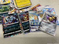 Close-up photo of select Japanese Pokémon cards showing characters and Japanese text.
