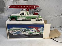 Side view of the 1994 Hess Rescue Truck on top of original box showing detailed decals and red ladder.