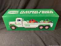 Box front showing the Hess flatbed truck with two hot rods on the back, green box with white and red details.