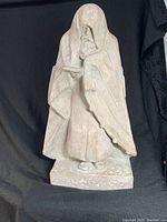 Front view of the Wise Man sculpture showing the robed figure holding an object.