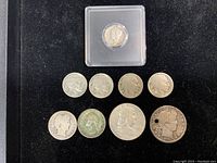 Obverse side of the 1921 Mercury Dime in protective case and front faces of other 7 coins including four Buffalo Nickels, one quarter, one half dollar, and one Mercury Dime with hole, showing coin designs and wear.