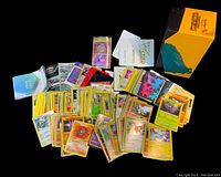 Overview of loose Pokémon cards spread out and some small packs and additional cards alongside the box