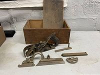 Overall view of Stanley tools and wooden box with sliding top on white surface