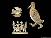 Three vintage sterling pins against black velvet background, showing each pin's details and markings.