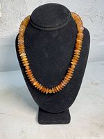Front view of vintage agate bead necklace displayed on black bust, showing bead color and shape.