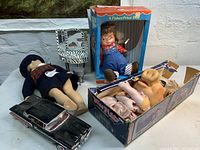 View of entire lot showing the Miss Piggy doll in box, the Fisher Price doll in its box, the vintage fashion doll, and the black toy car.