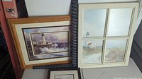 Top view showing all three lighthouse prints with frames, laid out on a flat surface