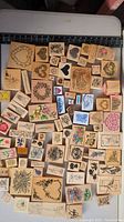 Photo showing wide array of wooden mounted rubber stamps with various designs including hearts, florals, animals, and nature scenes.